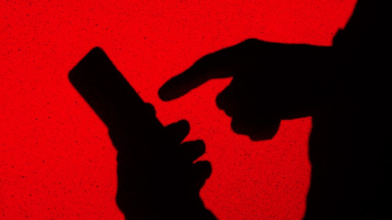 Shadow of a person operating a smartphone